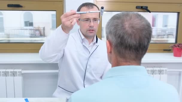 一名男性神经科医生在诊所进行例行检查时 在病人眼前扔锤子 — 图库视频影像