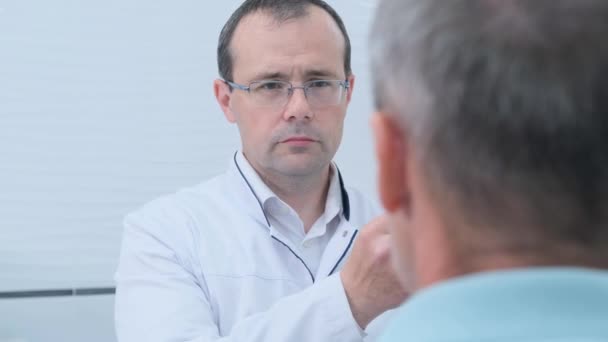 Męski Neurolog Prowadzi Młotek Oczach Pacjentów Podczas Rutynowego Badania Klinice — Wideo stockowe