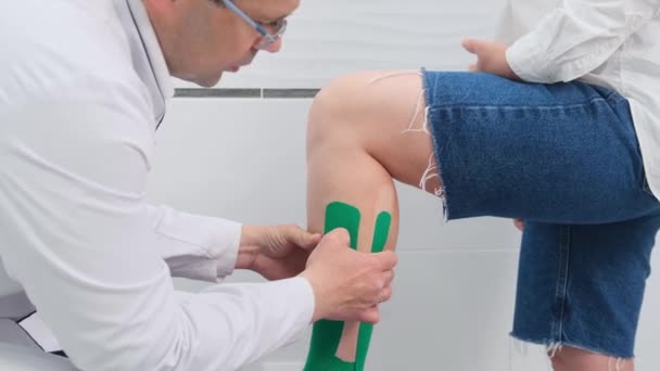 Traumatolog Vyšetřuje Pacientovu Nohu Zranění Lékařská Náplast Noze Pacienta — Stock video