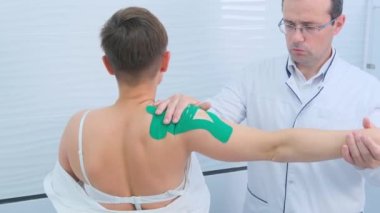 Bir ortopedik travmatolog hastaların omuz eklemlerini muayene eder ve ofisteki hareketlerini kontrol eder..