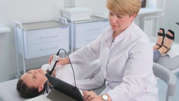 现代诊断诊所的医生在超声波机上检查一位年轻貌美女性病人的甲状腺 预防甲状腺癌 — 图库视频影像