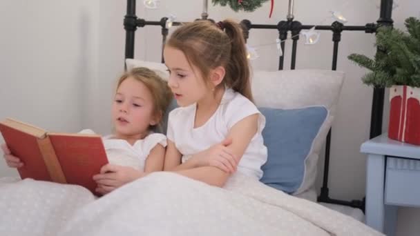 Dwie Małe Dziewczynki Czytające Książkę Białym Łóżku — Wideo stockowe