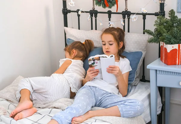 Eine Ältere Schwester Liest Ihrer Jüngeren Schwester Die Eingeschlafen Ist — Stockfoto