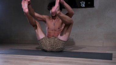 Yoga. Genç bir adam yoga yapıyor. Sağlıklı yoga yaşam tarzı kavramı olan bir şehir stüdyosunda karmaşık asanas gösterisi yapıyor.