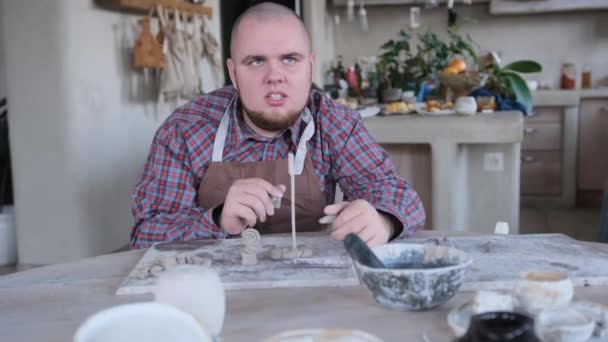自閉症症の若者の肖像画 陶芸のワークショップで大きなテーブルに座って — ストック動画