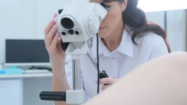 一名身穿白色西服的医生在妇科诊所检查一名阴道镜女病人的侧视图 — 图库视频影像