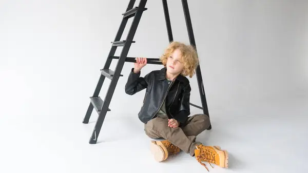 Young Child Blonde Curly Hair Seated Casually Ground Leaning Dark — Stock Photo, Image