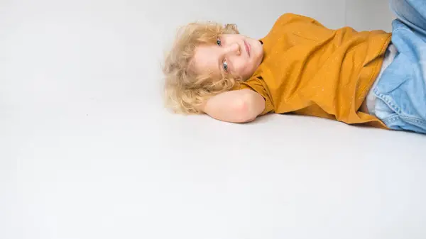 Kıvırcık Saçlı Bir Çocuk Açık Gri Bir Arka Plana Karşı Stok Fotoğraf