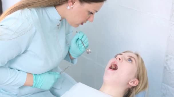 Dentista Examina Los Dientes Paciente Con Espejo Dental Consultorio Limpio — Vídeo de stock