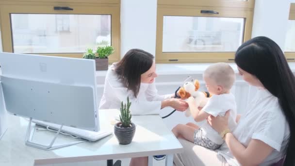 在母亲的注视下 医生在一次健康检查中与婴儿互动 — 图库视频影像