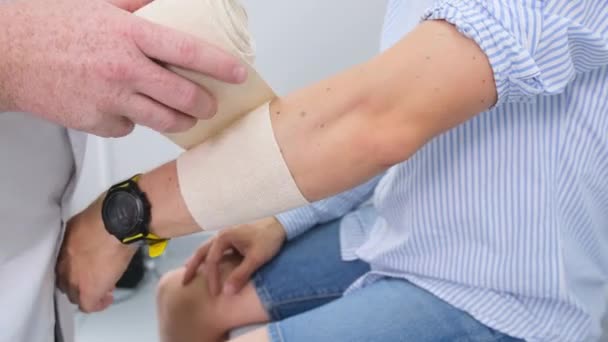 Pracownik Medyczny Nakłada Bandaż Ranną Rękę Pacjenta — Wideo stockowe