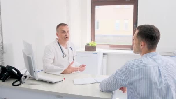 Bir Doktor Bir Tıp Bürosundaki Masada Otururken Bir Hastayla Sohbet — Stok video