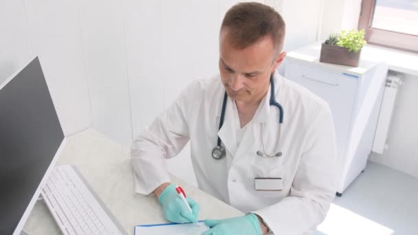 Beyaz Önlüklü Bir Tıp Uzmanı Ofis Ayarlarına Notlar Yazmaya Odaklanır — Stok video