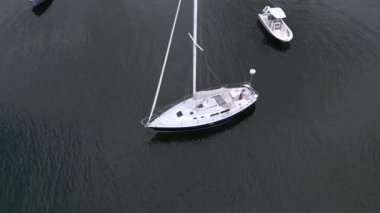 Sudaki bir yelkenliyi çevreleyen İHA.