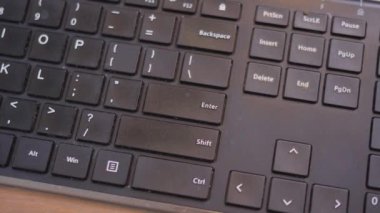 Yavaş çekimde siyah bir klavyede enter tuşuna basılıyor