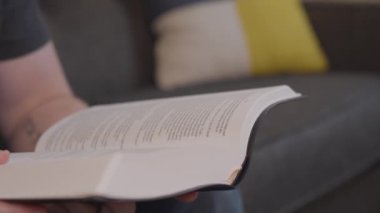 Bir kitabı açıp 4K sayfasını çeviren kişi