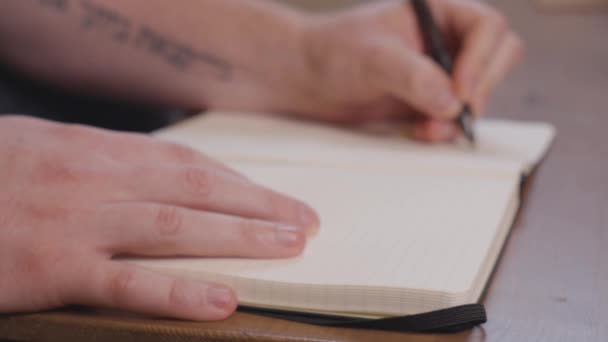 Eine Person Schreibt Mit Schwarzem Stift Auf Eine Weiße Seite — Stockvideo