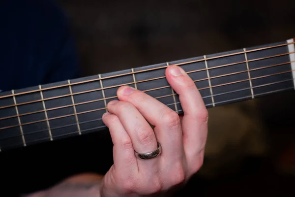 男の手が優雅にアコースティックギターのコードを演奏し 魂と共鳴する調和のとれたメロディーを織る — ストック写真
