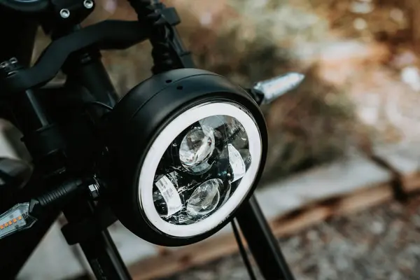 クローズアップショットは 夜空の下のオフロードアドベンチャーのスリルを象徴するダートバイクのヘッドライトの明るい光をキャプチャします ロイヤリティフリーのストック写真