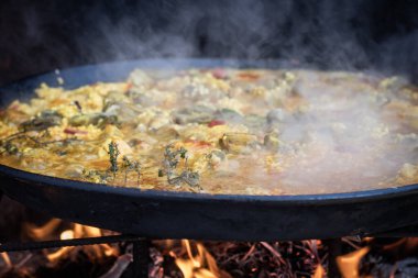 Ateşte pişmiş büyük bir paella, tipik İspanyol yemekleri.