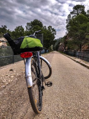 Bereketli yeşilliklerle çevrili sakin bir patikada park edilmiş bir bisiklet doğa ve açık hava aktiviteleri arasındaki bağlantıyı gözler önüne seriyor, keşif ve maceraya davetiye çıkarıyor..