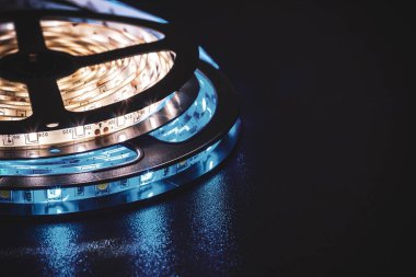 Bu resim güzel organize edilmiş LED ışıkları sergiliyor sıcak ve serin tonlarda, parlak siyah bir yüzeyi aydınlatıyor, modern ışıklandırma tasarımını temsil ediyor..