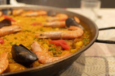 Lezzetli karides ve midyelerden oluşan canlı bir deniz ürünleri paella 'sı taze malzemelerin rengarenk bir karışımını ve mükemmel bir baharat karışımını sunuyor..