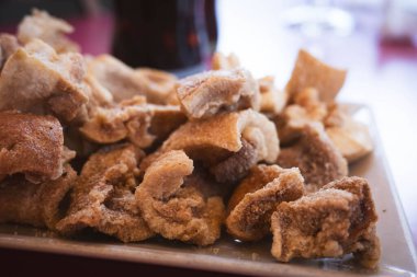 Kızarmış domuz burnu tapa 'sının cömert bir sunumunun yakın plan görüntüsü, altın-kahverengi dokularını gözler önüne seriyor, lezzetli bir aperatif için mükemmel, ya da çeşitli yemekler için..