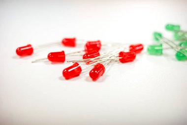  Beyaz bir yüzeye dağılmış kırmızı ve yeşil ışık yayan diyotlar. Devrelerde, DIY projelerinde ve teknoloji uygulamalarında kullanılan elektronik bileşenler.