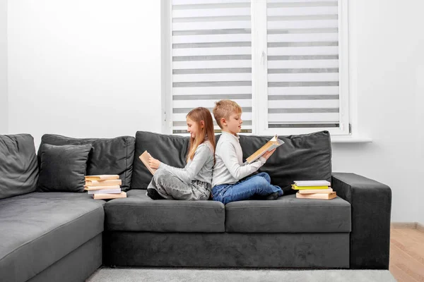 若いカップルがソファに座って本を読んで — ストック写真