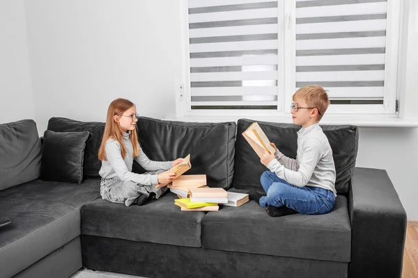 어린이들 안에서 소파에 안경으로 읽는다 형제자매들은 숙제를 공부하고 — 스톡 사진