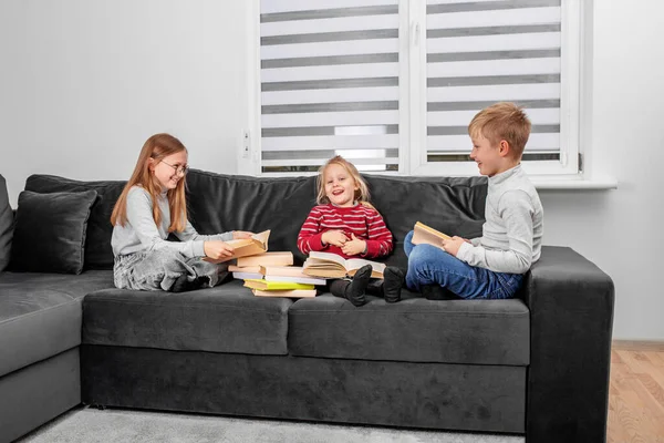 Children Sitting Sofa Reading Book Home — Stock Photo, Image
