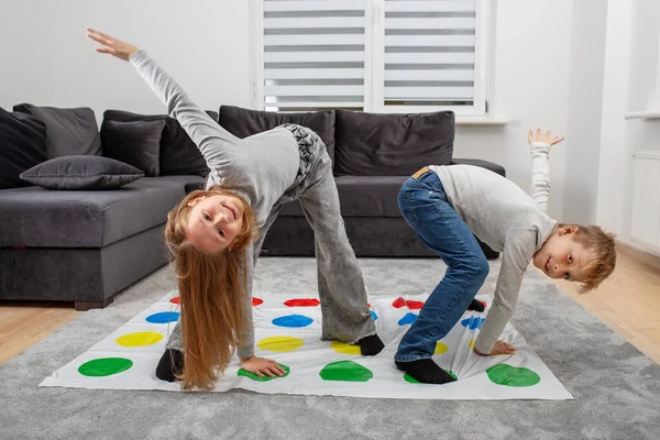 Group of children playing twister game and having fun. Concept of family, active leisure and holidays