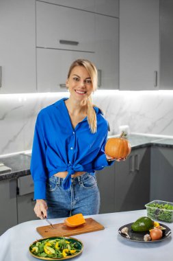Genç bir kadın mutfakta sebze salatası hazırlıyor. Sağlıklı gıda, diyet ve ekolojik gıda kavramı. Şükran Günü.