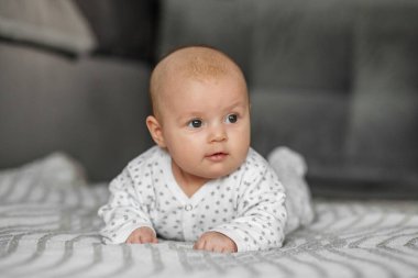 Çocuk bakımı konsepti. Evde battaniyeye uzanmış bebek portresi. Seçici odak, boşluğu kopyala.