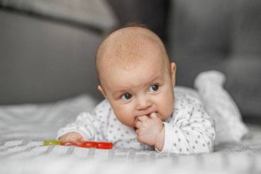Tatlı bebek yatakta uzanıp kameraya bakıyor.