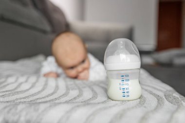 Çocuk bakımı konsepti. Bebek mamasıyla, bebek mamasının içinde küçük şirin bir bebeğin portresi. Seçici odak, boşluğu kopyala.