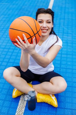 young beautiful woman with basketball ball on blue background. Close up