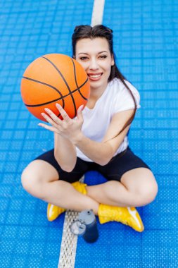 young beautiful woman with ball on blue background