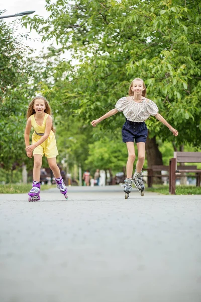 Two children are rollerblading at skate park. Concept of an active lifestyle, hobbies and childhood.