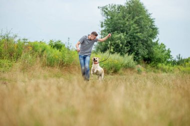 young man with dog walking in the field