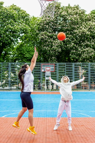 Concept of sports, hobbies and healthy lifestyle. Young people playing basketball on playground outdoors
