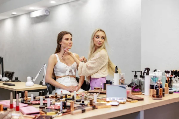 Make up artist work in beauty visage studio salon. Woman applying by professional make up master. Apply makeup to face. Skin care. Small business.