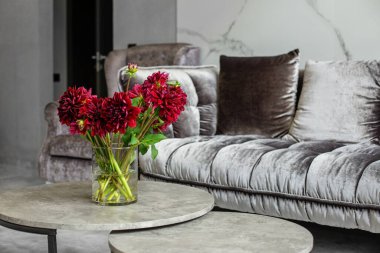 Bouquet of red dahlia in interior. Beautiful modern interior and fresh flowers.