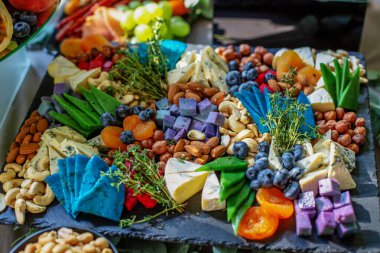 Biberiyeli peynir tabağı ve ahşap tahtada fındık, üst manzara.