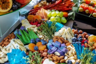 Biberiyeli peynir tabağı ve ahşap tahtada fındık, üst manzara.