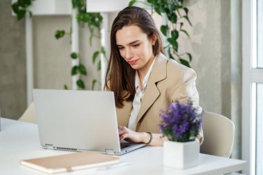 Kadın modern ofiste dizüstü bilgisayarda çalışıyor. Muhasebe analizi yapmak gayrimenkul yatırım verileri, mali ve vergi sistemleri kavramı