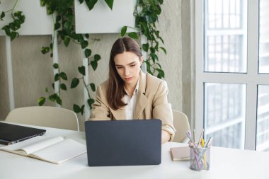 Kadın modern ofiste dizüstü bilgisayarda çalışıyor. Muhasebe analizi yapmak gayrimenkul yatırım verileri, mali ve vergi sistemleri kavramı
