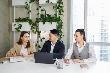 Bitkileri olan modern bir ofis. Projeyi tartışan çok ırklı bir grup insan, ofiste beyin fırtınası toplantısında birlikte iletişim kuruyorlar.