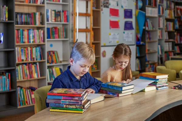 Kisiskolások Együtt Olvasnak Könyveket Miközben Könyvtárban Ülnek Asztalnál Fiú Lány — Stock Fotó
